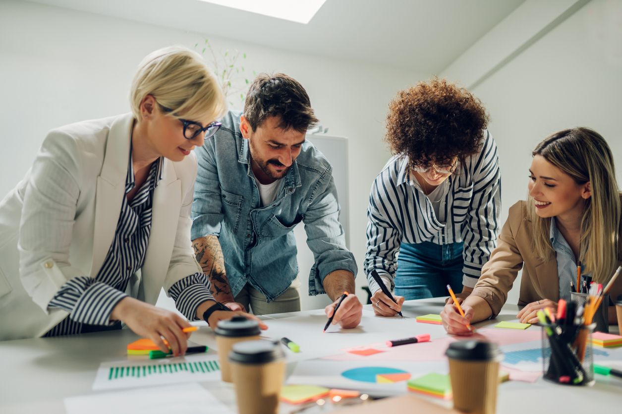 Cheerful diverse office people group talking and enjoying teamwork during staff meeting. Happy multiracial coworkers have fun working together at office brainstorming. Teamwork concept.