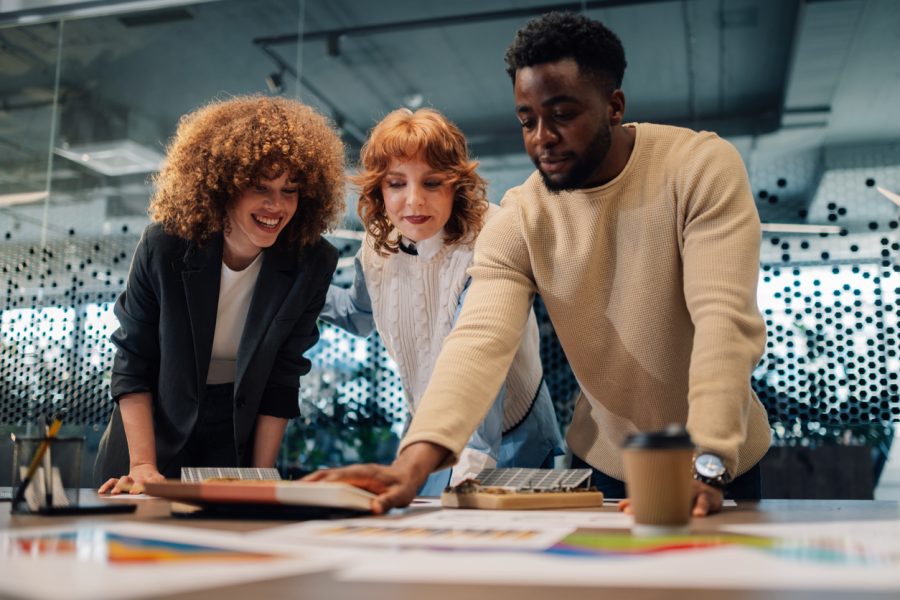 Portrait of innovative businesspeople standing at modern boardroom with paperwork and working on solar energy technology development and implementation. Eco couscous staff working on renewable energy.