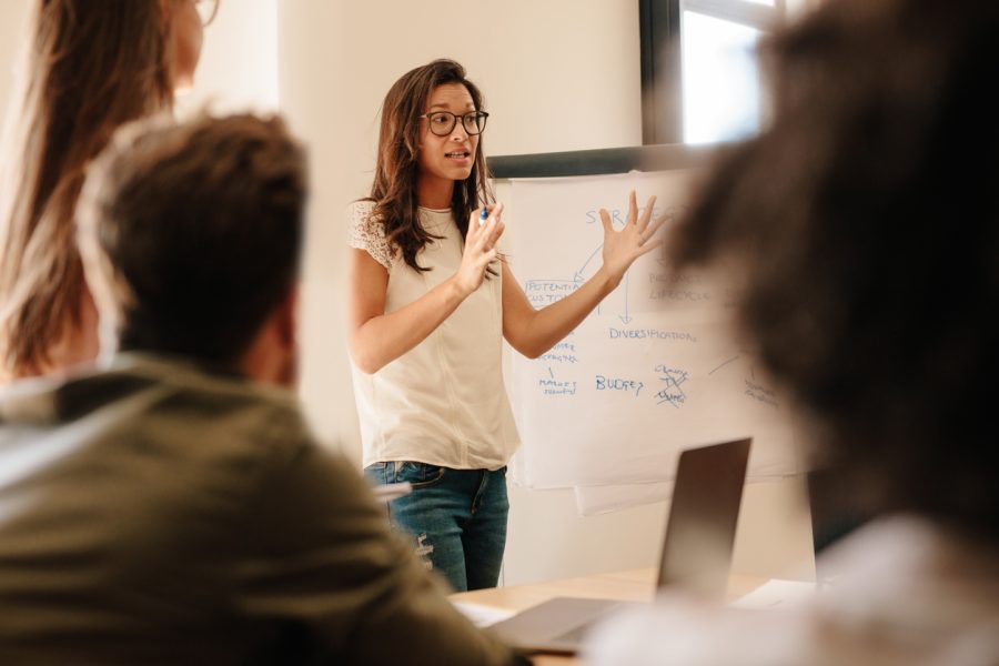 Businesswoman explaining new plan to colleagues in conference room. Businesspeople during meeting in office board room.
